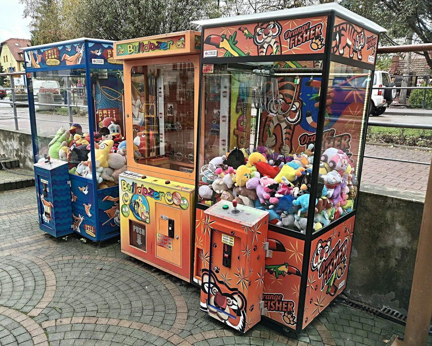 Colourful claw machines full of plush on a street corner