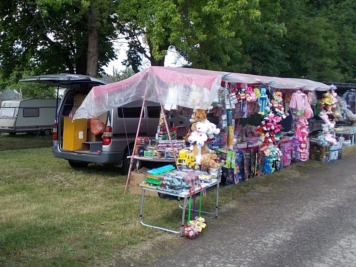 An outdoor market stall covered in plush toys